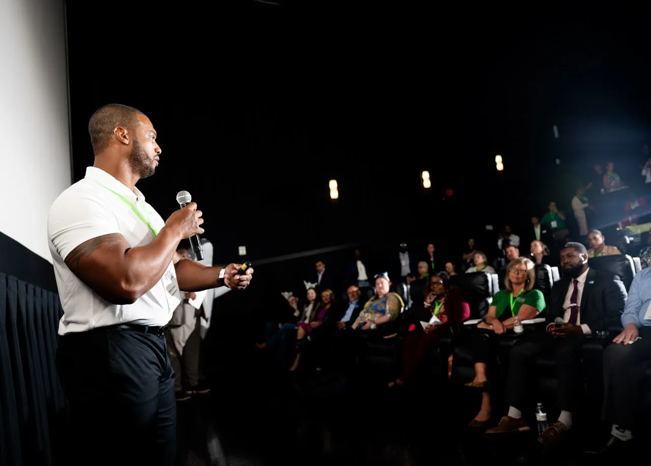 Coach speaking to an audience at a workplace event