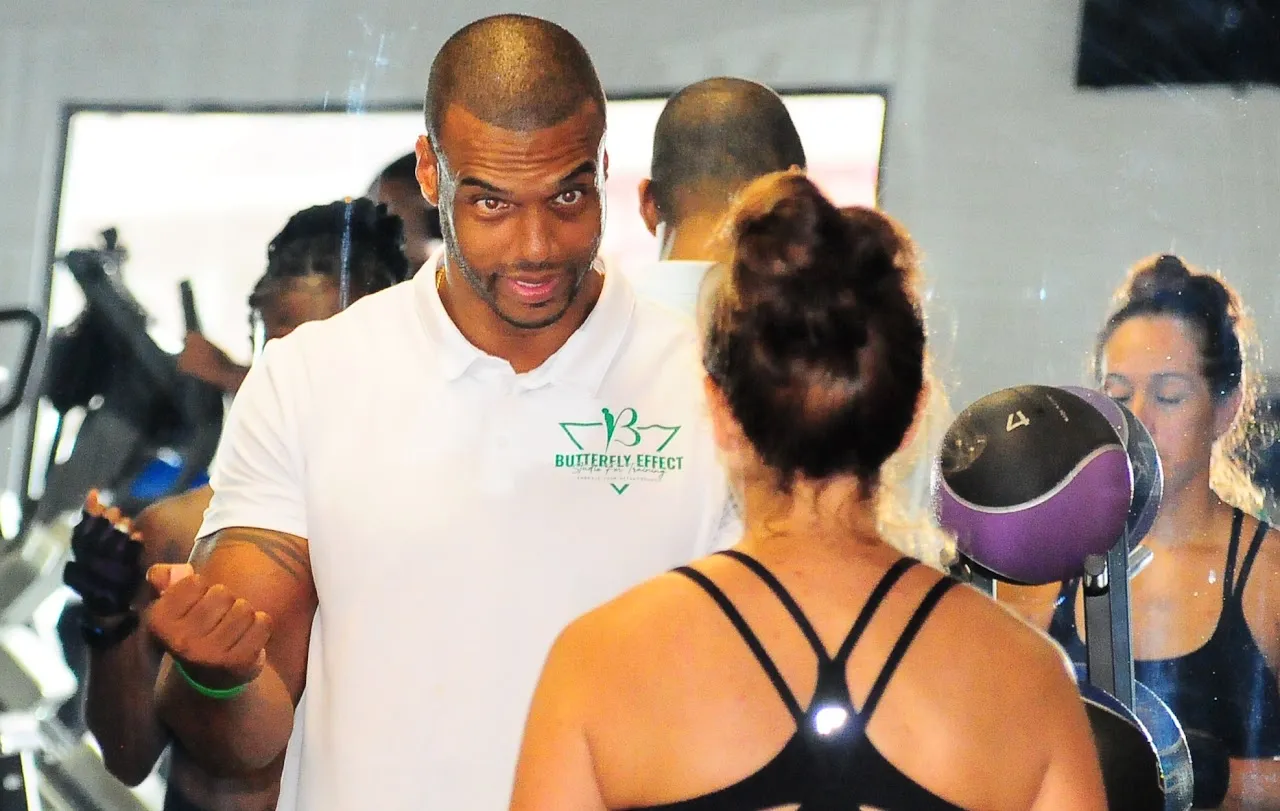 Coach guiding a client through a personal training session